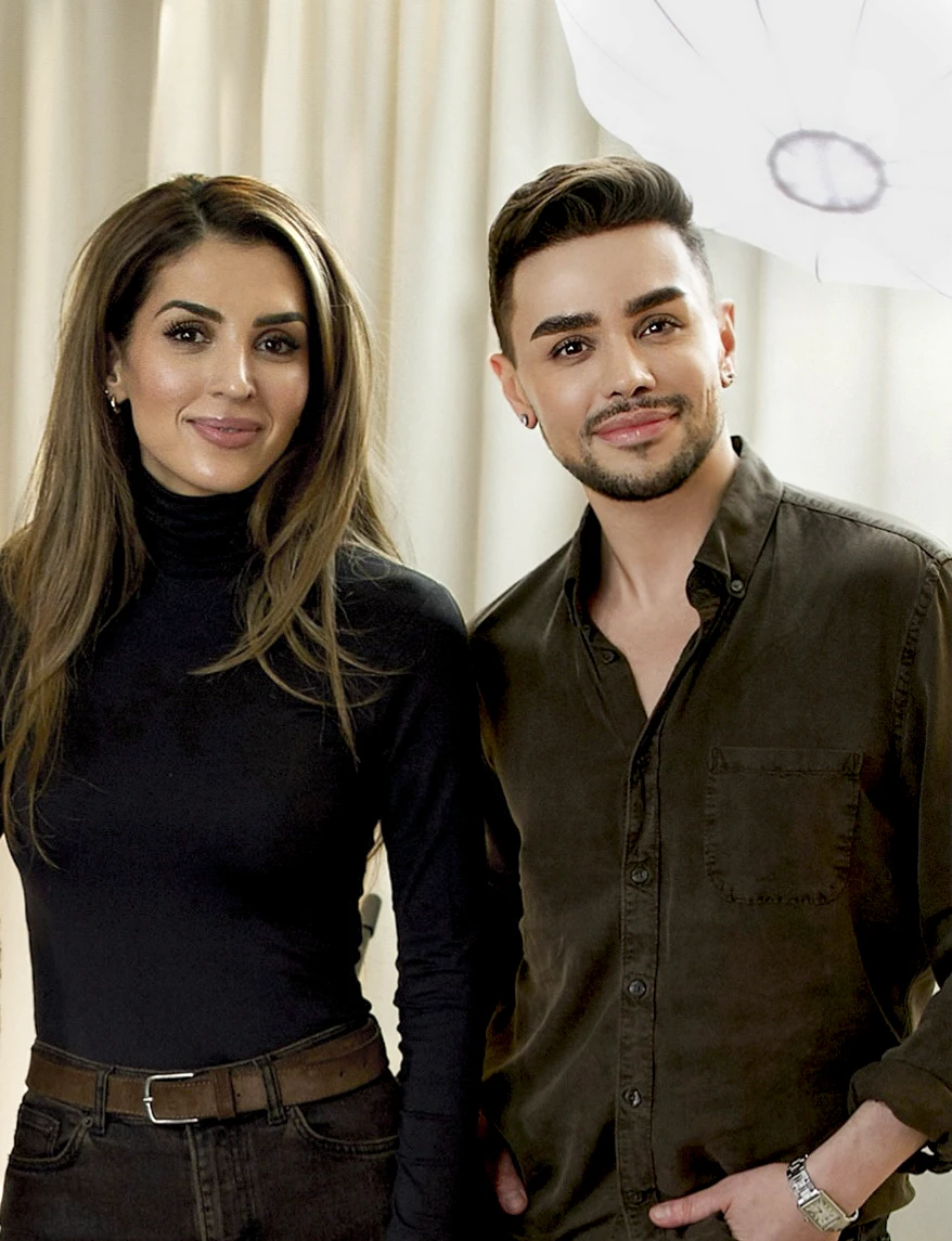 To personer står ved siden av hverandre foran en lys bakgrunn, med stylet makeup som foundation og definerte øyenbryn samt naturlig leppemakeup innen skjønnhet.