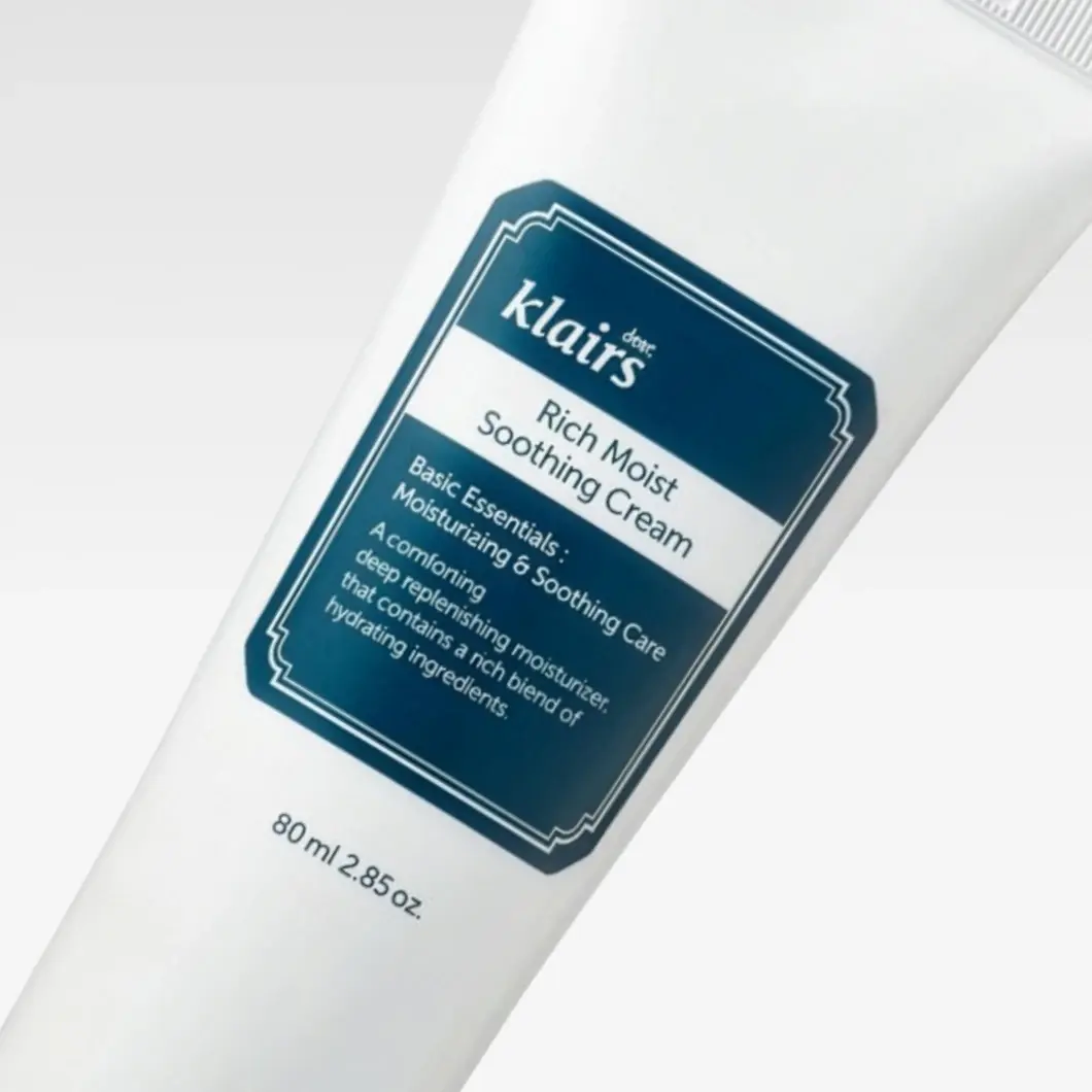 Klairs Rich Moist Soothing Cream i en vit tub visas mot en ljus bakgrund. På förpackningen syns texten "Rich Moist Soothing Cream", "Basic Essentials: Moisturizing & Soothing Care", "A comforting deep replenishing moisturizer that contains a rich blend of hydrating ingredients." samt "80 ml / 2.85 oz."