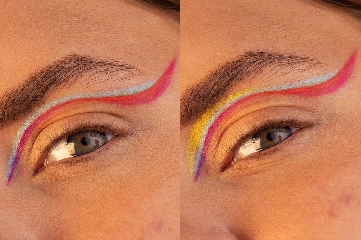 Närbild av två ögon med färgglad och konstnärlig eyeliner i blått, rött, gult och lila