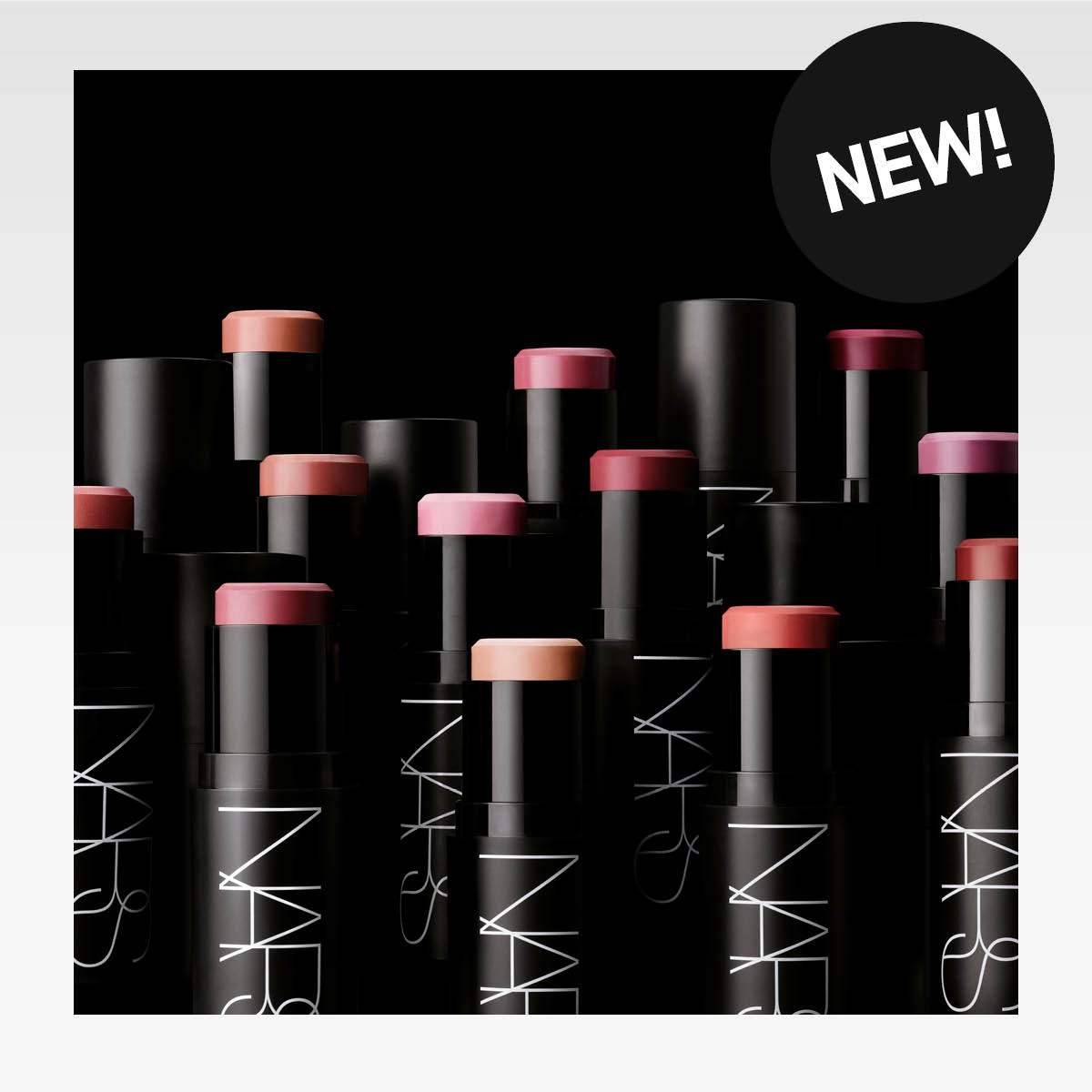Flera NARS-läppstift arrangerade i en cirkel. Läppstiften har olika nyanser, såsom rosa, röd, orange och brun.