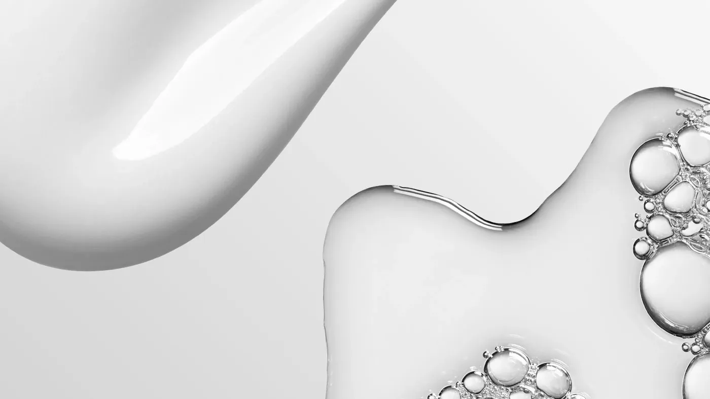 Transparent vätska med bubblor mot en grå bakgrund