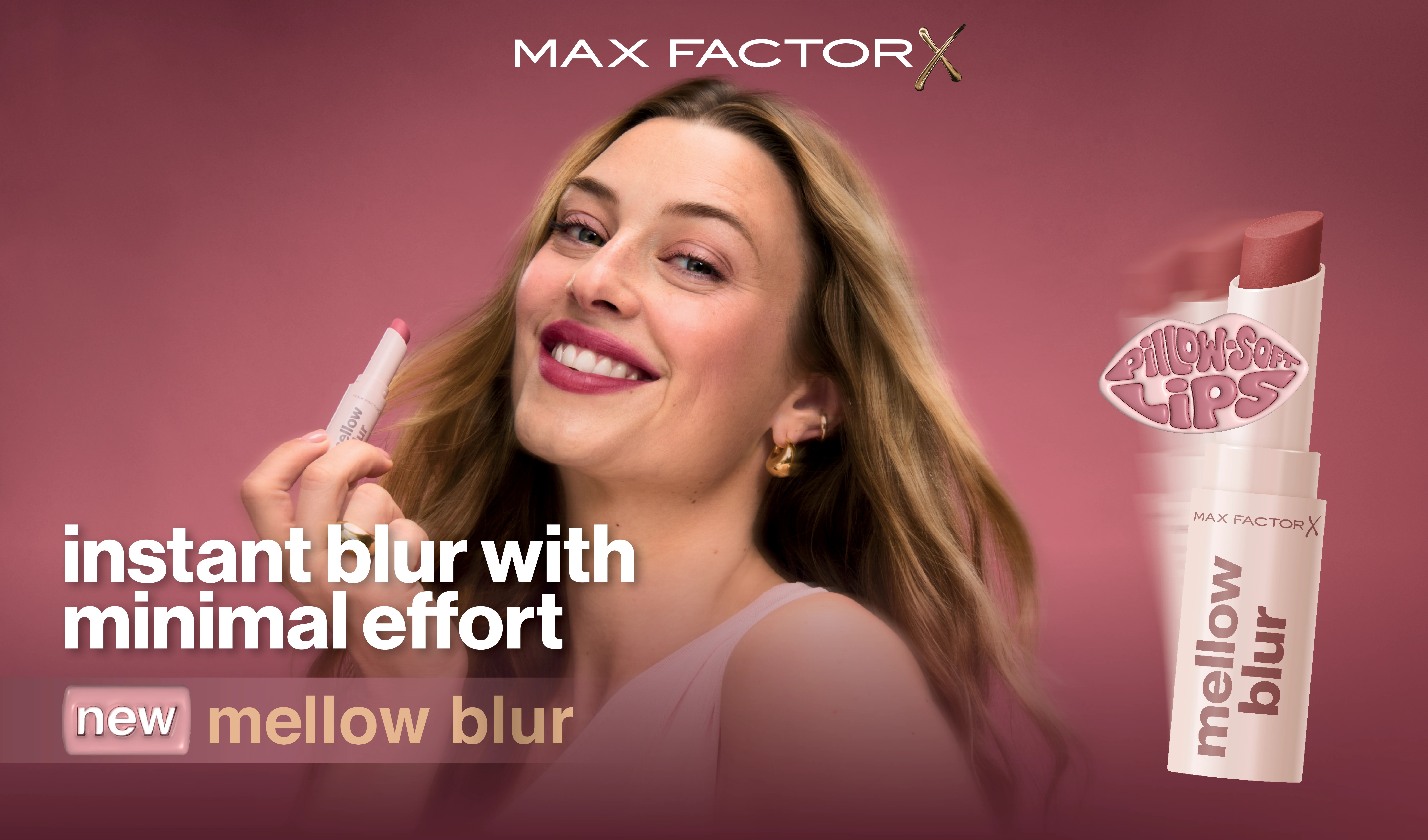 En person smiler og holder en Max Factor leppeprodukt, med teksten “instant blur with minimal effort” og “new mellow blur”, samt produktvisning på rosa bakgrunn.
