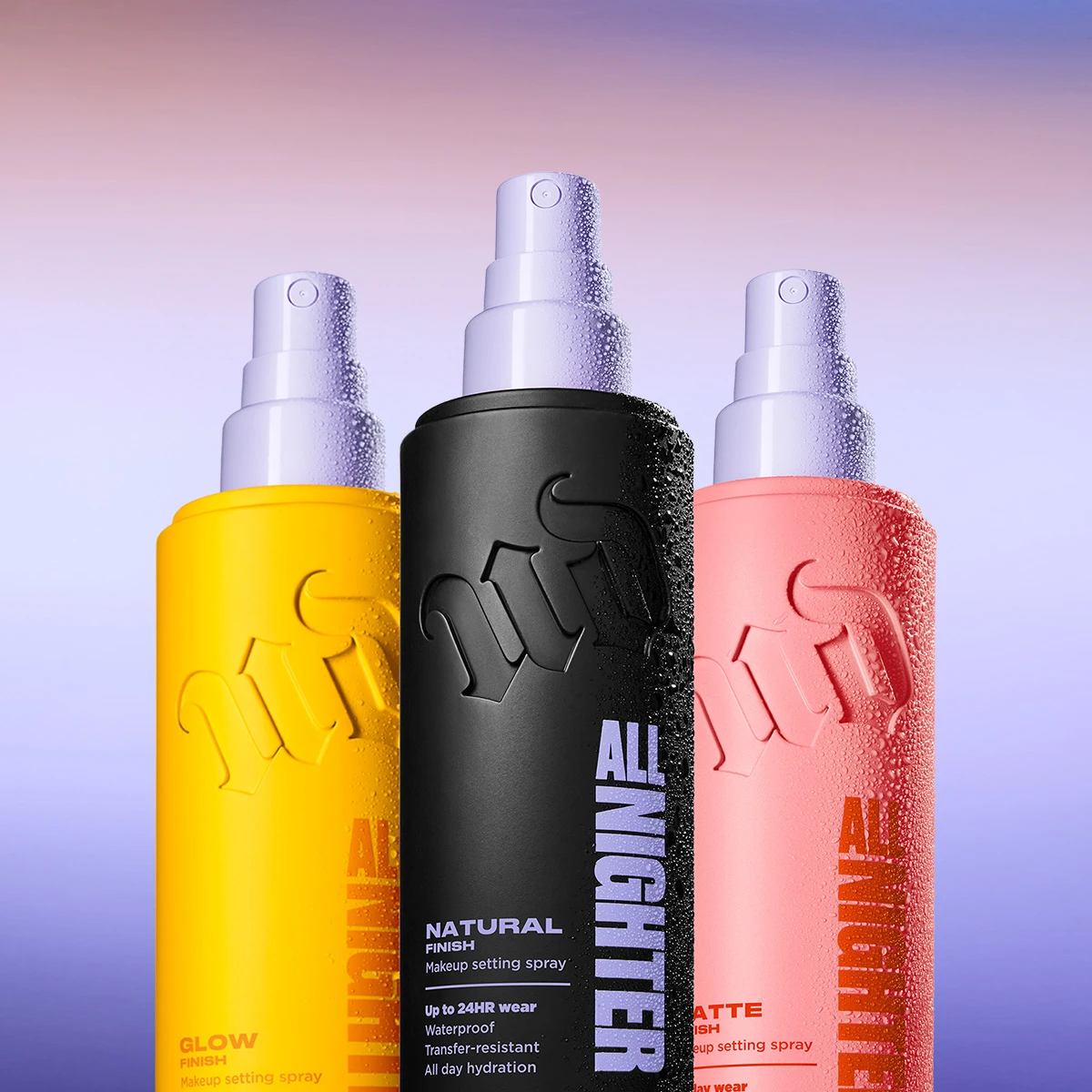 Urban Decay All Nighter-settingsprayer med olika finishar mot ljuslila bakgrund.