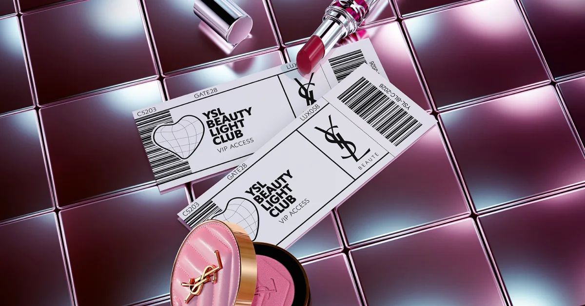 Yves Saint Laurent Beauty -tuotteita kiiltävällä vaaleanpunaisella ruutukuviotaustalla. Kuvassa näkyy kaksi lippua teksteillä ”YSL BEAUTY LIGHT CLUB VIP ACCESS”, YSL Beauté -logo, viivakoodeja sekä tekstit ”GATE28”, ”C5203” ja ”LUX058”, yhdessä vaaleanpunaisen huulipunan ja avoimen vaaleanpunaisen puuterin kanssa, jossa on YSL-logo.