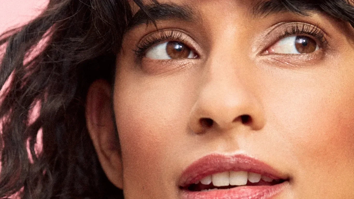 Kvinna med bruna ögon, mörkt hår och naturligt bronserad makeup.