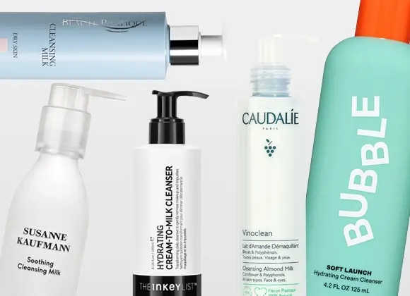 Flere hudpleieprodukter i form av rensemelk fra blant annet Susanne Kaufmann, The Inkey List, Caudalie og Bubble skincare, med pumpeflasker og tuber mot en lys bakgrunn. Synlig tekst inkluderer “Soothing Cleansing Milk”, “Oat Cleansing Balm”, “Vinoclean Cleansing Almond Milk” og “Milky Silky Calming Cleansing Lotion”.