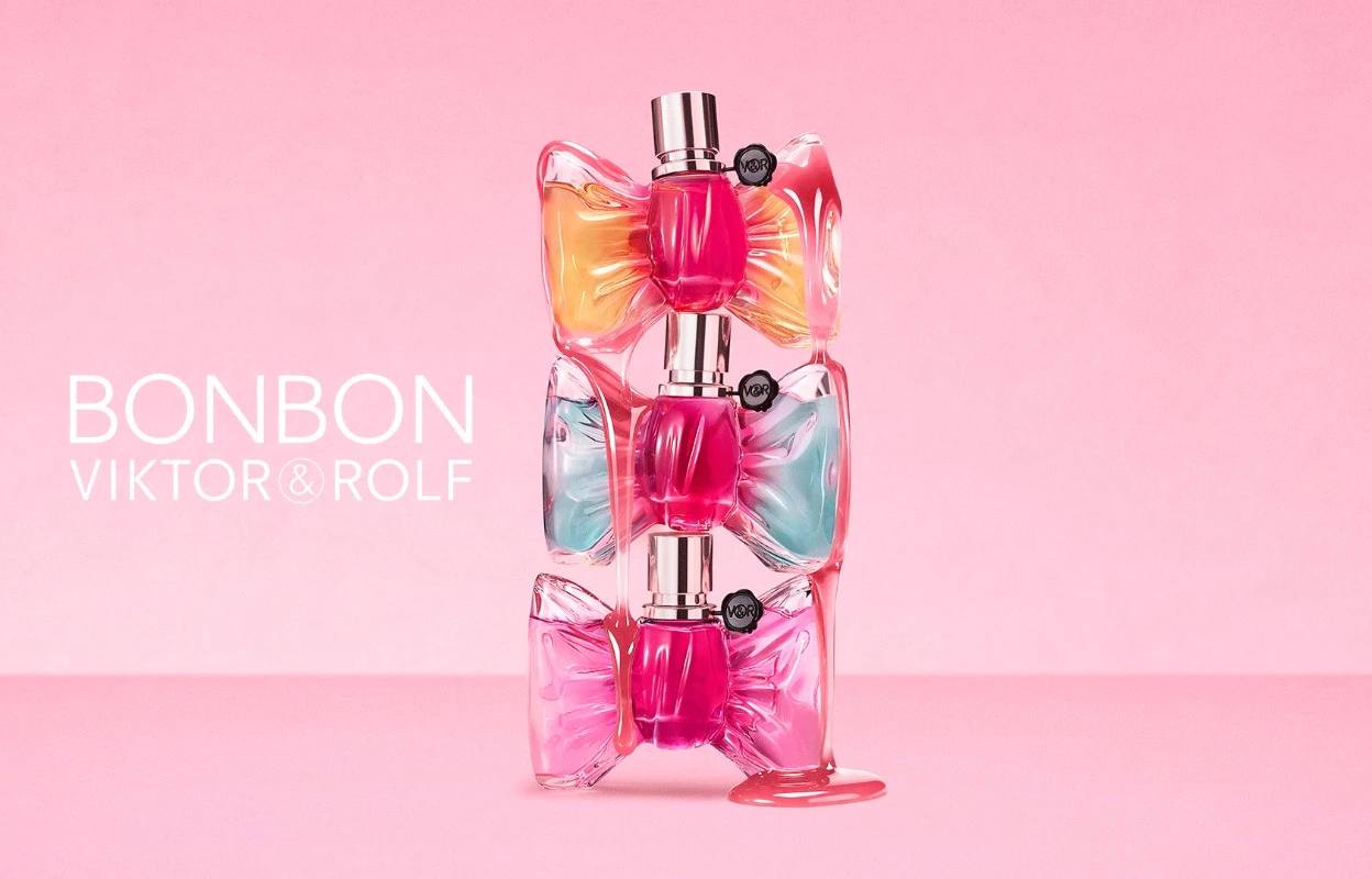 Tre Viktor&Rolf Bonbon-parfymeflasker er stablet oppå hverandre mot en rosa bakgrunn. Flaskene har sløyfeformet design i rosa, oransje og lyseblå nyanser med synlig tekst: "BONBON" og "VIKTOR&ROLF".