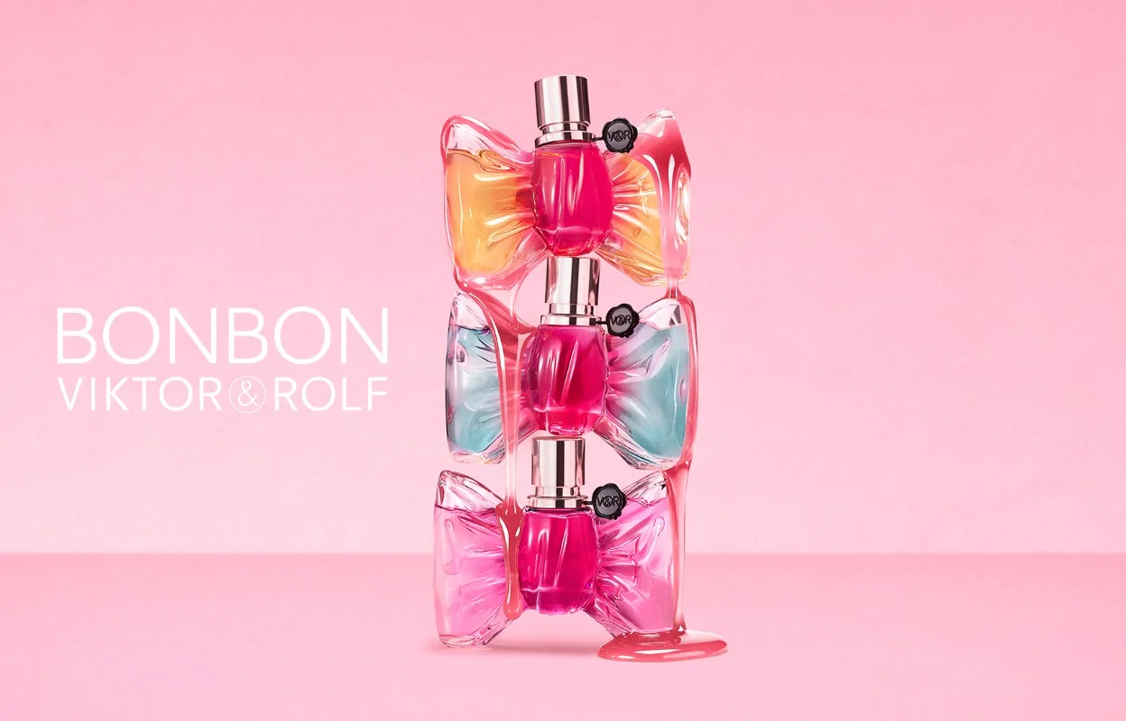 Tre Viktor&Rolf Bonbon-parfymeflasker er stablet oppå hverandre mot en rosa bakgrunn. Flaskene har sløyfeformet design i rosa, oransje og lyseblå nyanser med synlig tekst: "BONBON" og "VIKTOR&ROLF".