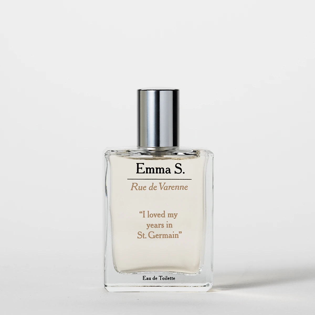 Transparent parfymeflaske fra Emma S med sølvfarget kork og teksten “Rue de Varenne”, “I loved my years in St. Germain” og “Eau de Toilette” på en lys bakgrunn.