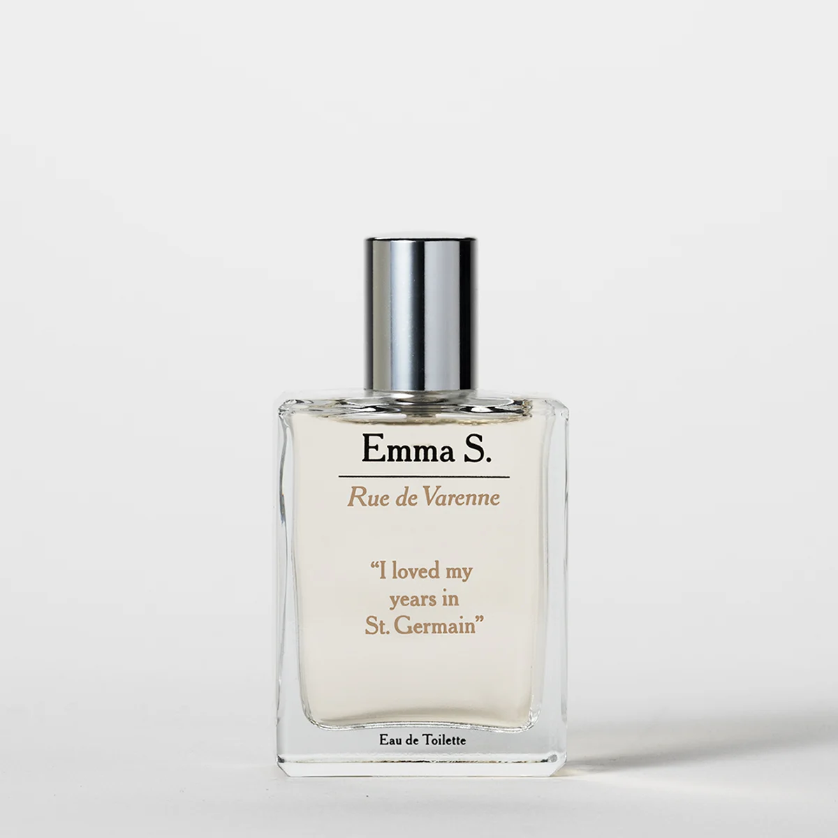 Transparent parfymeflaske fra Emma S med sølvfarget kork og teksten “Rue de Varenne”, “I loved my years in St. Germain” og “Eau de Toilette” på en lys bakgrunn.