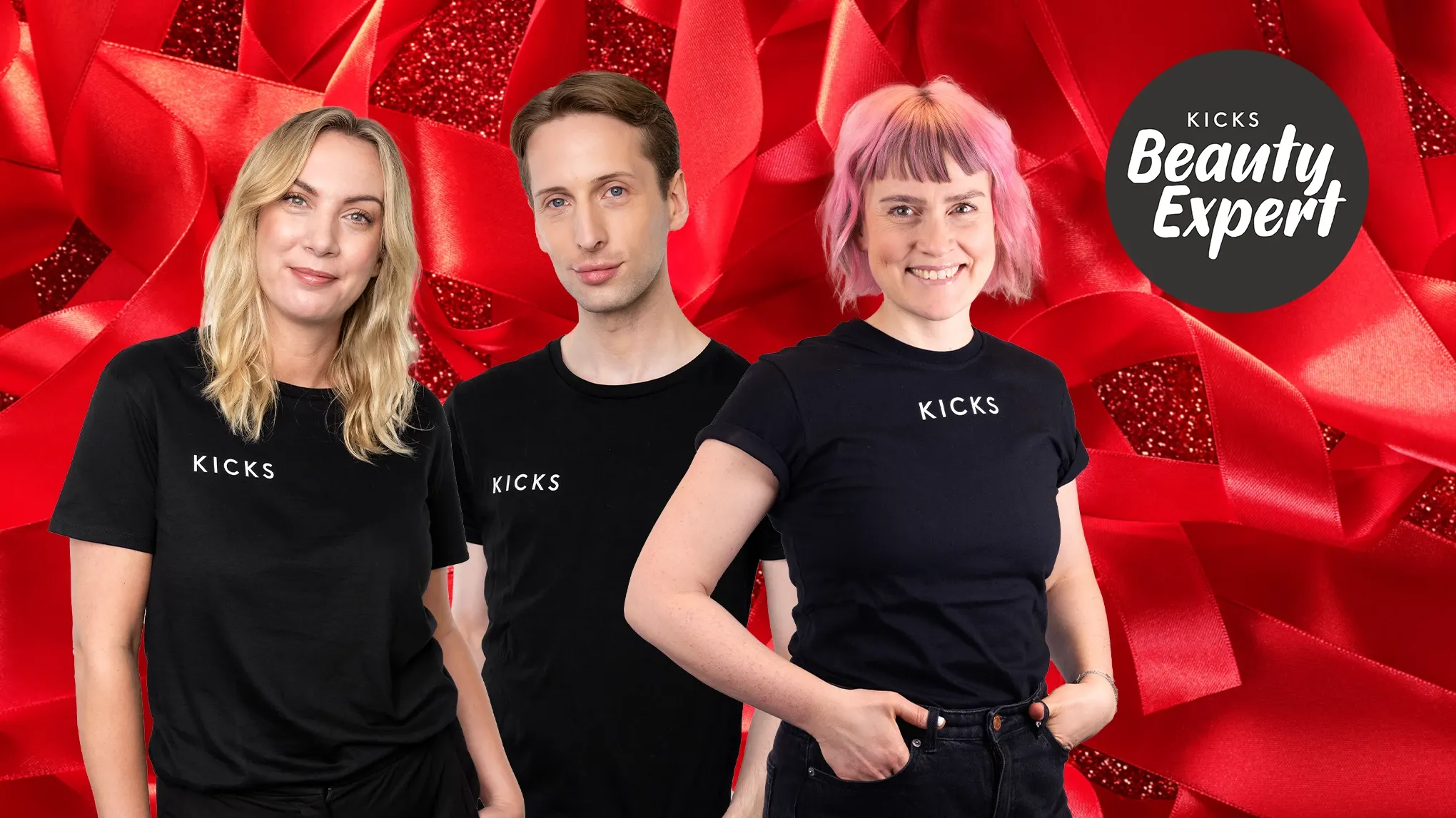 Kolme henkilöä mustissa KICKS-paidoissa seisoo punaisen taustan edessä, jossa lukee "KICKS Beauty Expert".