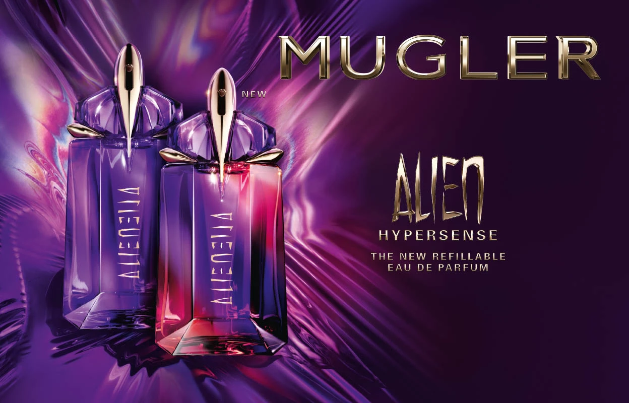 To parfymeflasker fra Mugler med navnet «Alien Hypersense». Flaskene har et futuristisk design i lilla og rosa nyanser med gylne detaljer. Bakgrunnen er et abstrakt lilla og rosa mønster. Teksten på bildet lyder «Mugler Alien Hypersense - The new refillable Eau de Parfum».