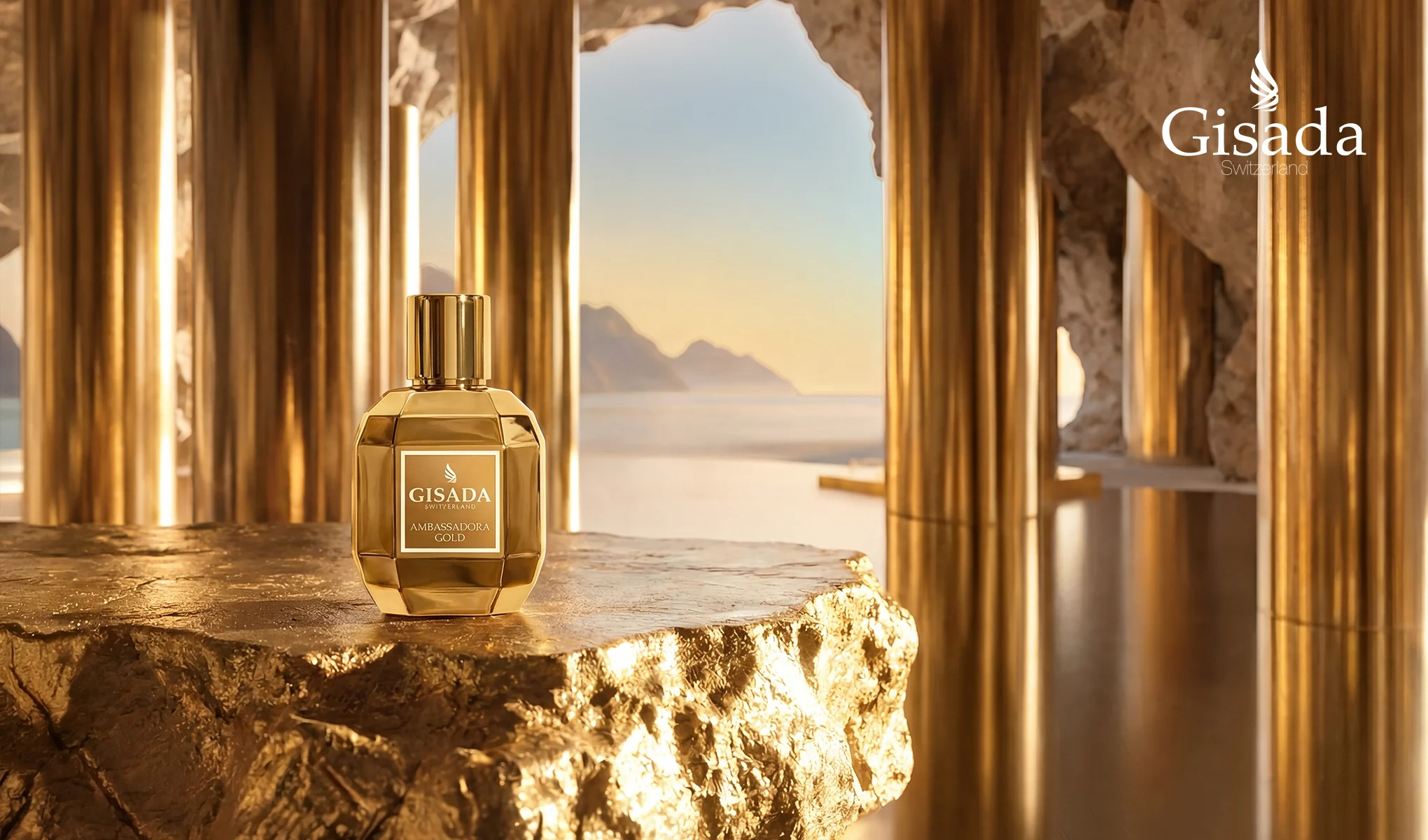 Gisada Switzerland Ambassadora Gold parfymeflaske i gullfarget design står på en skinnende gyllen steinplattform. I bakgrunnen vises gullfargede søyler, klippeformasjoner, hav og fjell i varmt lys, samt teksten «Gisada Switzerland» og etiketten «GISADA SWITZERLAND AMBASSADORA GOLD».