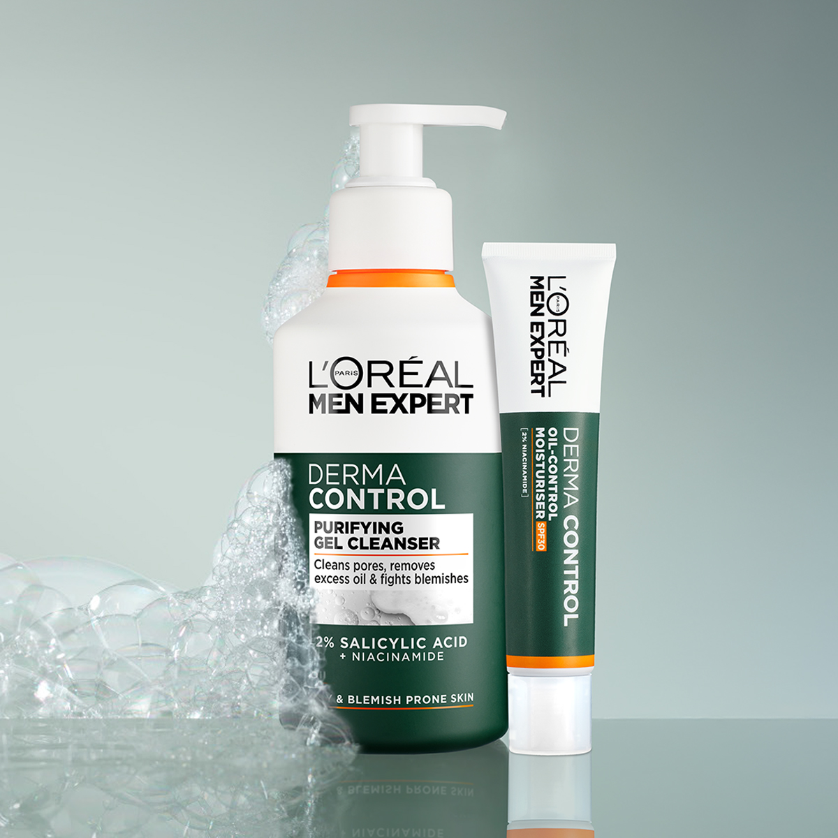 Kaksi L'Oréal Men Expert -tuotetta vierekkäin kiiltävällä pinnalla. Pumppupullo puhdistusgeeliä ja tuubi kosteusvoidetta. Vaahdot ympäröivät pulloa.