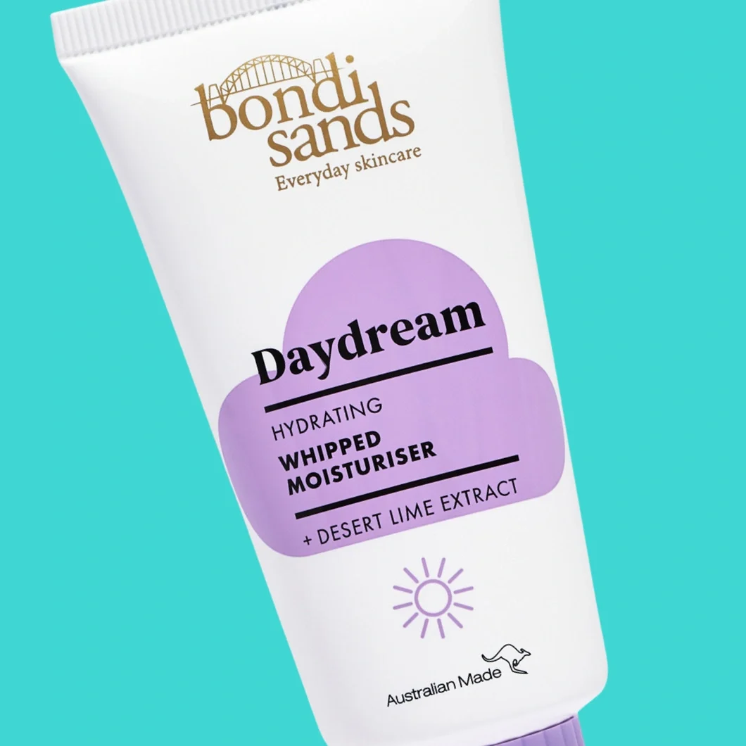 Bondi Sands Daydream Hydrating Whipped Moisturiser ansiktskräm i en vit tub mot turkos bakgrund. På förpackningen syns texterna "Bondi Sands Everyday Skincare", "Daydream", "HYDRATING WHIPPED MOISTURISER", "+ DESERT LIME EXTRACT" och "Australian Made".