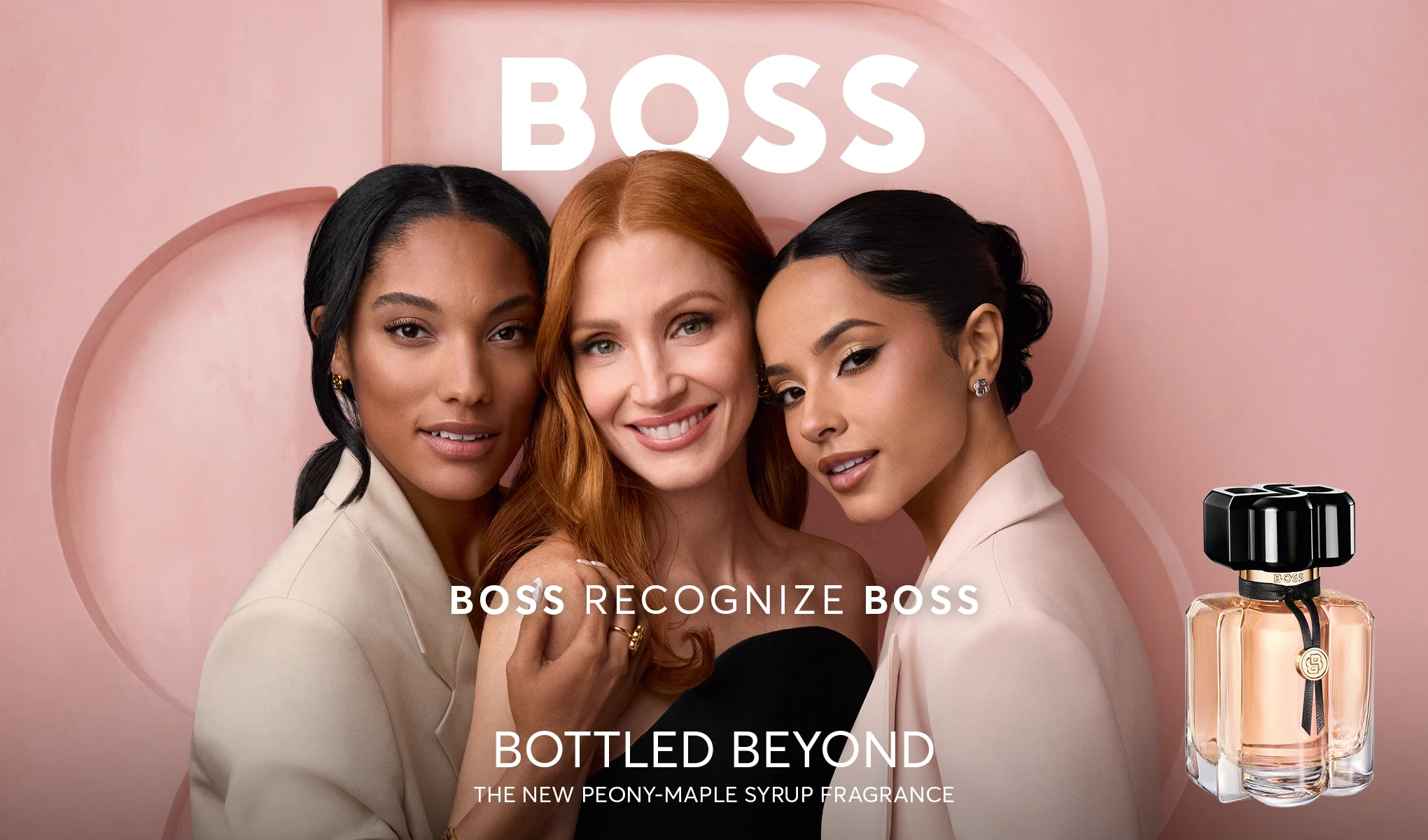 Kolme henkilöä poseeraa yhdessä vaaleanpunaisella taustalla BOSS Bottled Beyond -hajuveden vieressä, joka on läpinäkyvässä pullossa mustalla korkilla. Näkyvä teksti: "BOSS", "BOSS RECOGNIZE BOSS", "BOTTLED BEYOND" ja "THE NEW PEONY-MAPLE SYRUP FRAGRANCE".