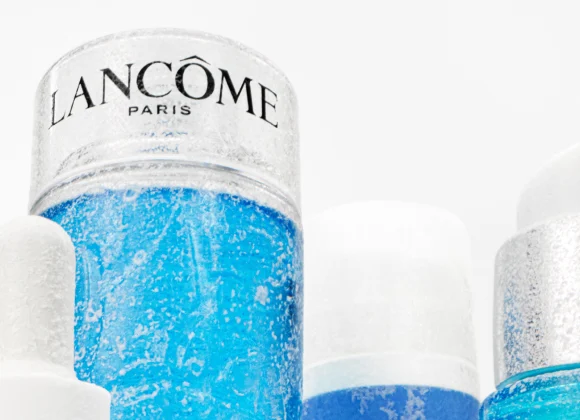 Produkt av Lancome underifrån tillsammans med andra produkter, mot en vit bakgrund