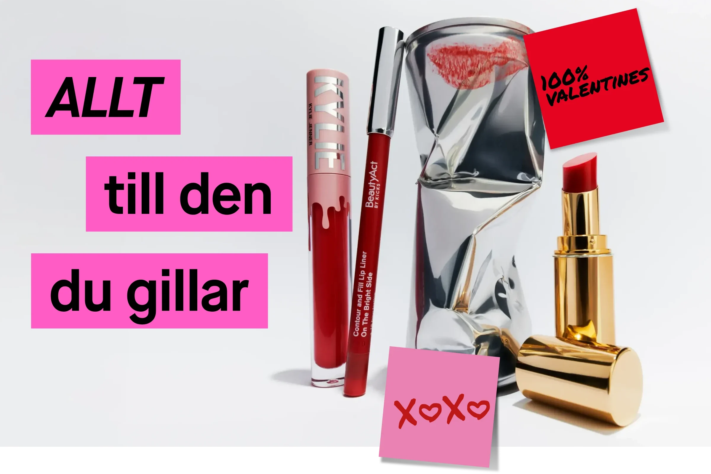 Skönhetsprodukter arrangerade med luft runt objekten mot ljus bakgrund. I bilden syns rött läppglans, röd läppenna, guldfärgat läppstift och en silverfärgad dekoration. Till vänster visas rosa textrutor med texten ”ALLT”, ”till den” och ”du gillar”. En röd lapp med texten ”100% Valentines” samt en rosa lapp med texten ”XOXO” visas.