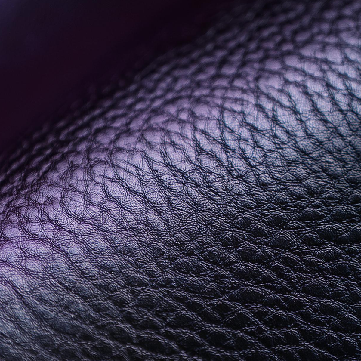 Lähikuva nahkarakenteesta, jossa on violetti hohto.