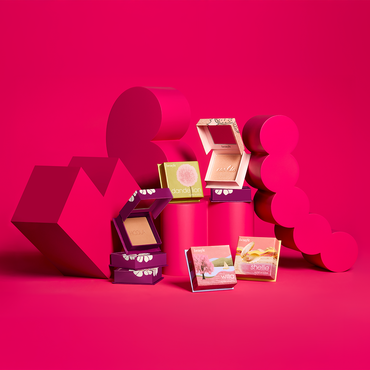 Fire primer-produkter fra Benefit på en rød bakgrunn. 