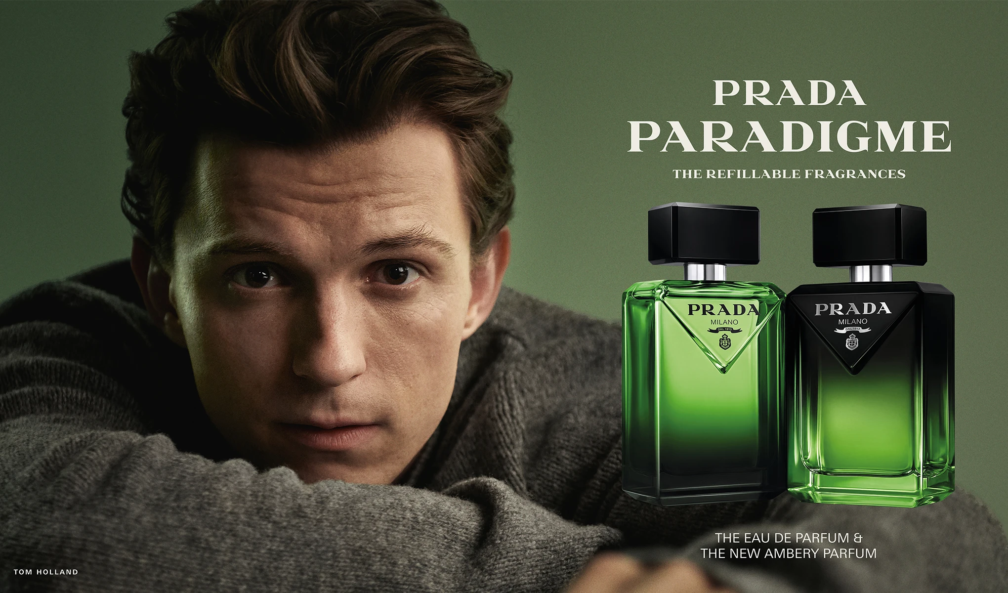 Tom Holland med två gröna Prada Paradigme parfymflaskor. Text: Prada Paradigme. The Refillable Fragrances. The Eau de Parfum & The New Ambery Parfum. Tom Holland.