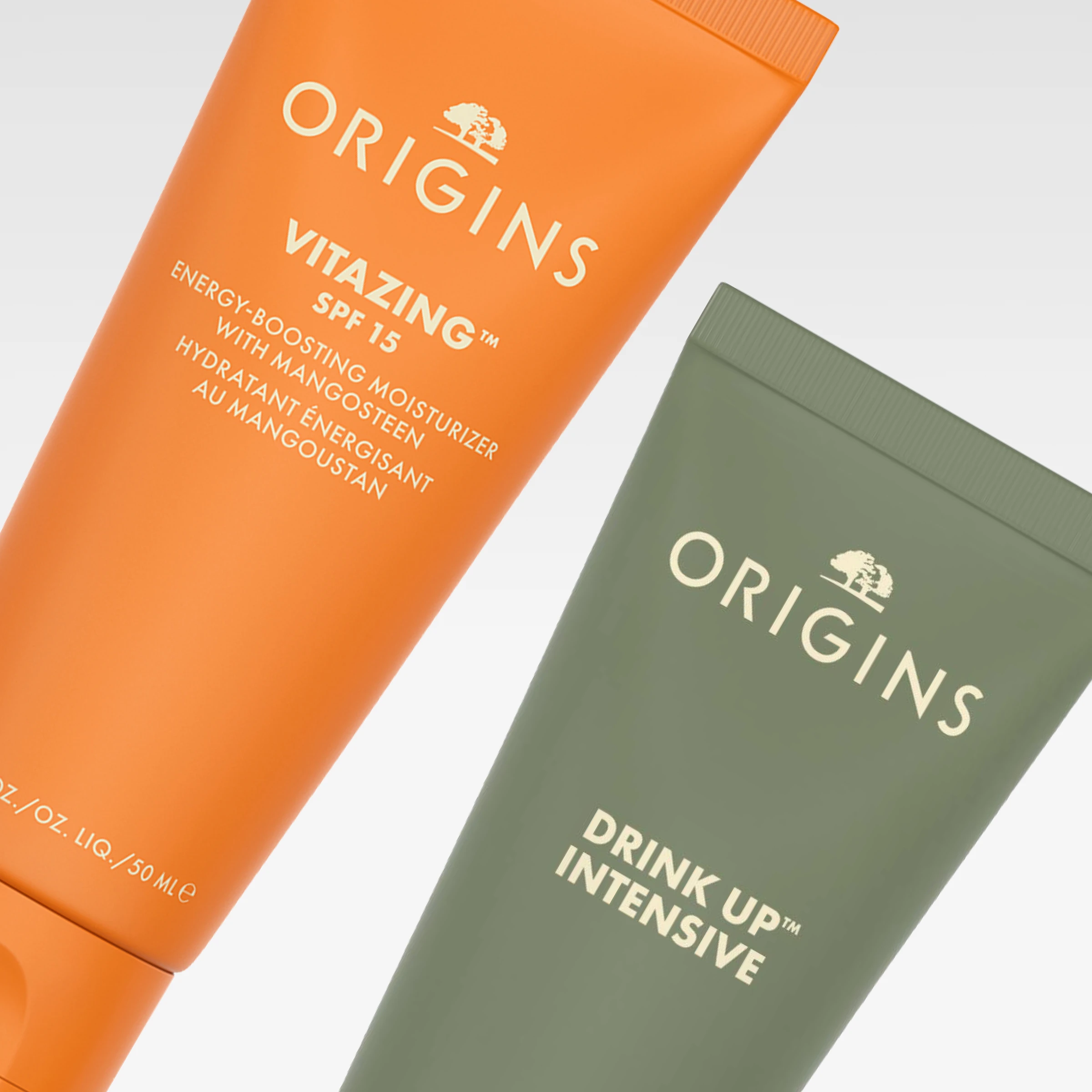 Origins hudvårdsprodukter i orange och grön tub med VitaZing SPF 15 och Drink Up Intensive mot ljusgrå bakgrund. Synlig text inkluderar “energy-boosting moisturizer with mangosteen” och “hydrating énergisant au mangoustan”.