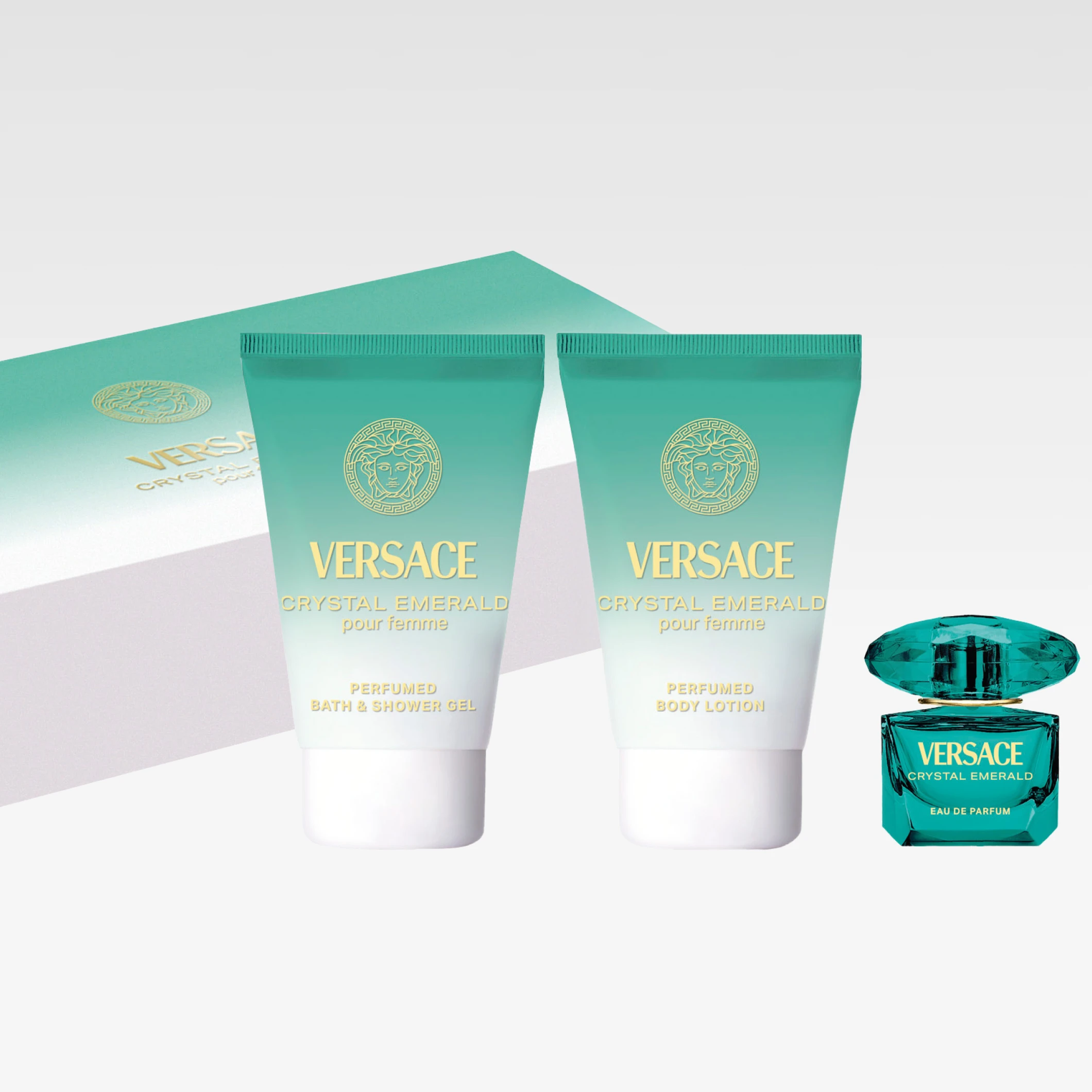 Versace Crystal Emerald parfymegave med turkise tuber og flaske samt emballasje i matchende farge. Tekst i bildet: "VERSACE CRYSTAL EMERALD pour femme", "PERFUMED BATH & SHOWER GEL" og "PERFUMED BODY LOTION".