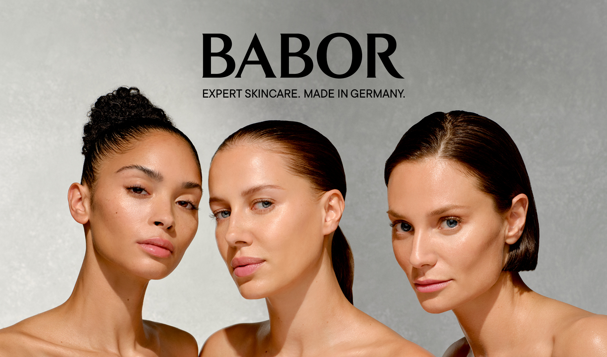 Ihmiset, joilla on erilainen ihonväri ja hiustyyli. He seisovat harmaata taustaa vasten. Heidän yläpuolellaan lukee teksti: ”BABOR EXPERT SKINCARE. MADE IN GERMANY.”.