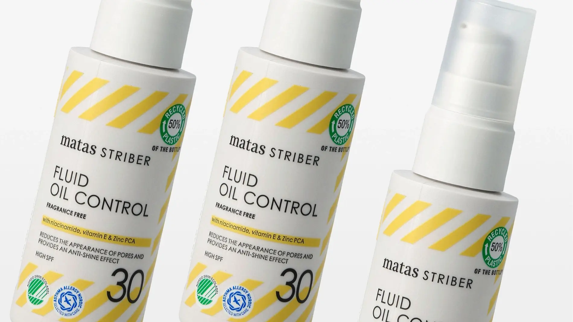 Kolme valkoista pumppupulloa Matas Striber Fluid Oil Control -ihonhoitotuotteesta aseteltuna vinosti, pakkauksessa keltaiset vinoraidat ja tekstit “FRAGRANCE FREE”, “with niacinamide, vitamin E & Zinc PCA” sekä “REDUCES THE APPEARANCE OF PORES AND PROVIDES AN ANTI-SHINE EFFECT”. Etiketissä näkyy myös “HIGH SPF 30” sekä symbolit “RECYCLED 50% PLASTIC”, “NORDIC SWAN ECOLABEL” ja “ASTHMA ALLERGY NORDIC”.
