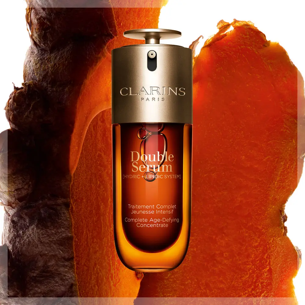 Clarins Double Serum -pullo, jossa on hehkuva, kultainen tausta. Pullossa on tyylikäs muotoilu, jossa on teksti ”Double Serum” ja ”Hydric + Lipidic System”.