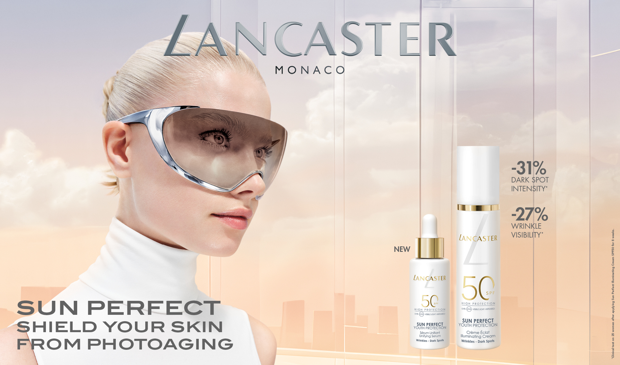 Henkilö, jolla on aurinkolasit ja valkoinen paita, seisoo vaalealla taustalla. Oikealla puolella on kaksi Lancaster-aurinkosuojatuotetta ja teksti "SUN PERFECT SHIELD YOUR SKIN FROM PHOTOAGING".