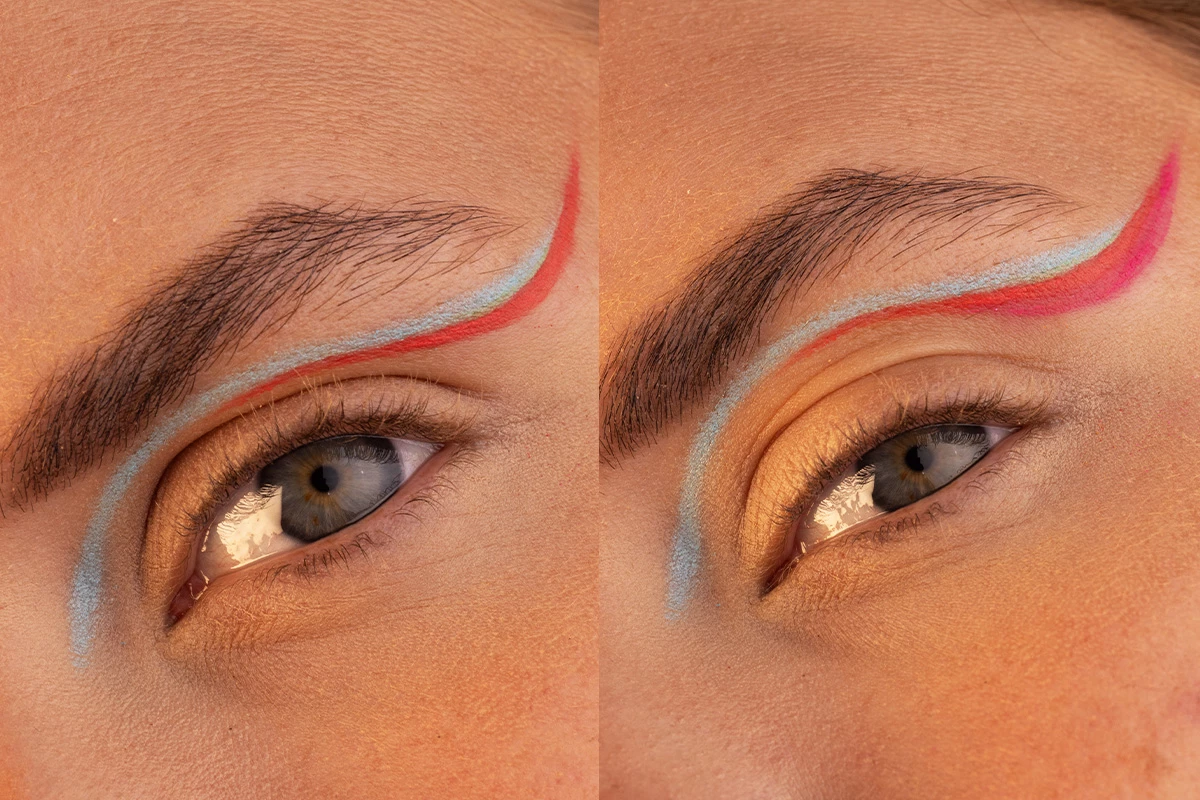 Närbild av två ögon med konstnärlig eyeliner i blått och rött, applicerad längs ögonlocket och upp mot ögonbrynet