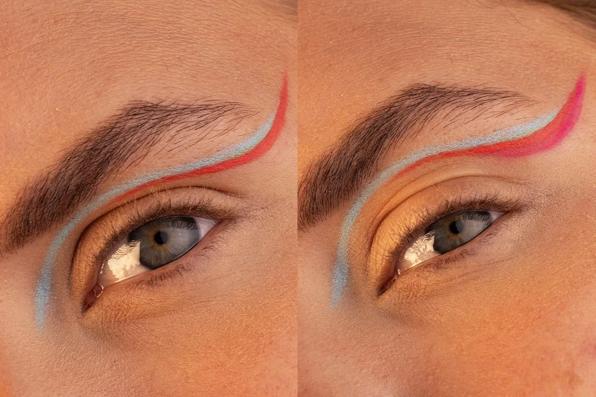 Närbild av två ögon med konstnärlig eyeliner i blått och rött, applicerad längs ögonlocket och upp mot ögonbrynet
