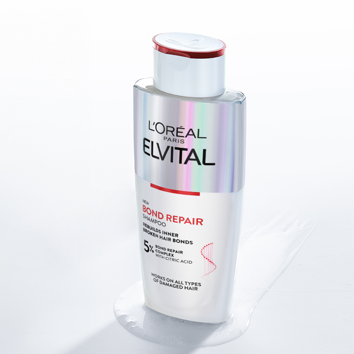 Yksi L'Oréal Elvital Bond Repair -sarjan hiustenhoitotuote on asetettu valkoista taustaa vasten. Tuotteessa on holografinen etiketti ja punaisia yksityiskohtia.