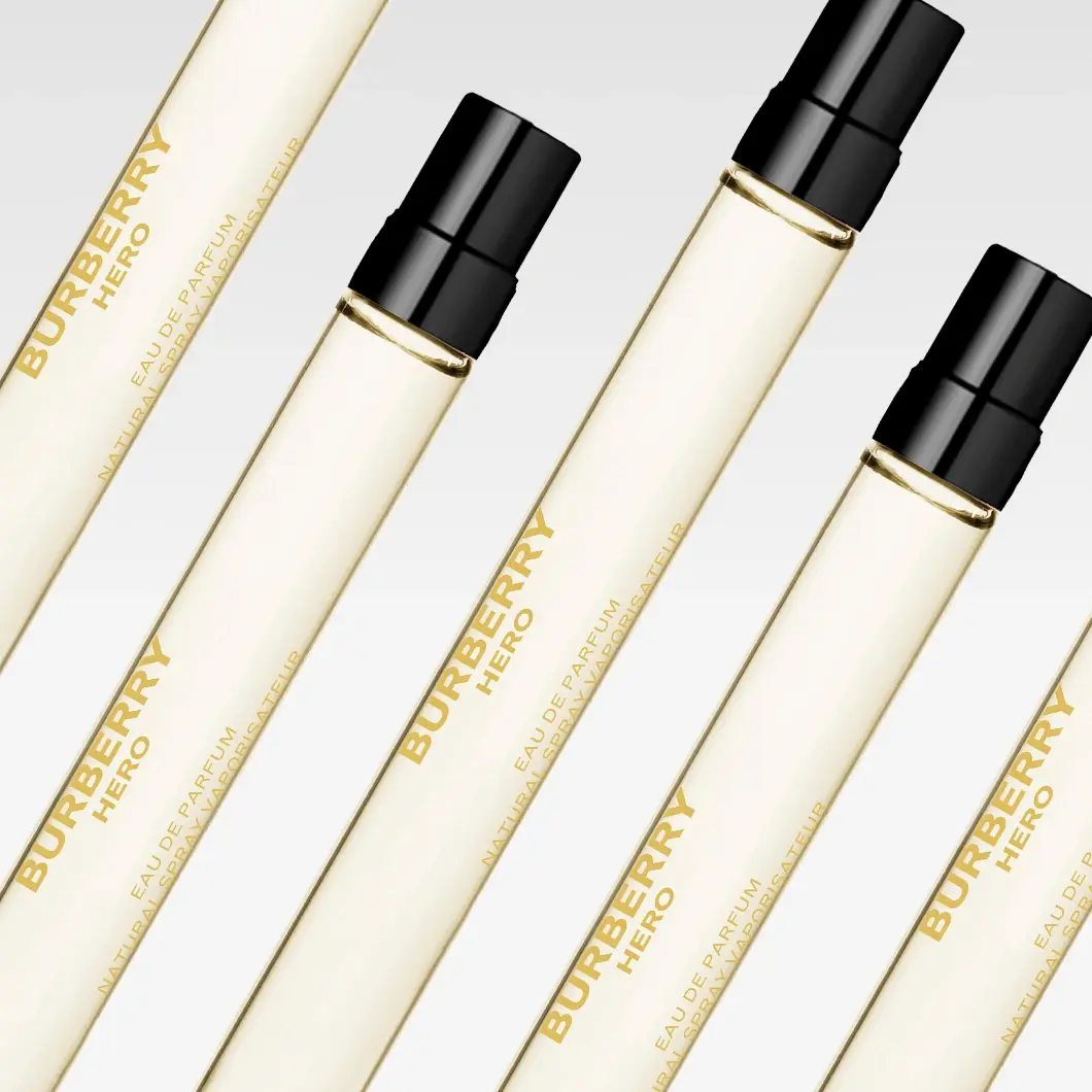 Flera Burberry Hero Eau de Parfum i avlånga, transparenta parfymflaskor med ljusgul vätska och svarta spraymunstycken. På flaskorna står ”BURBERRY HERO”, ”EAU DE PARFUM” och ”NATURAL SPRAY VAPORISATEUR”.