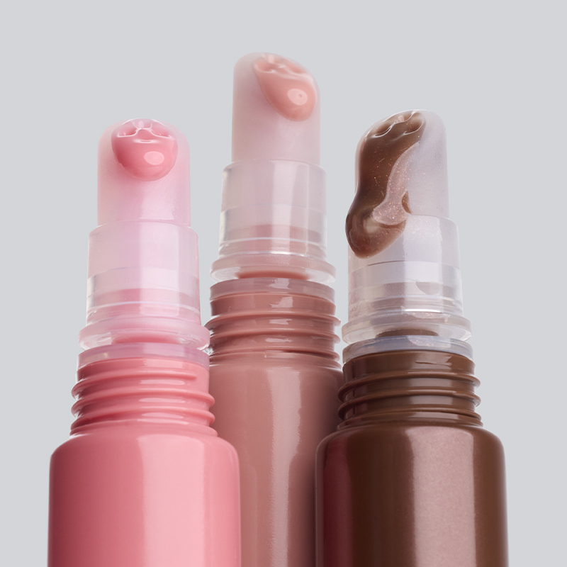 Tre IsaDora leppeprodukter i rosa, nude og brun nyanse med kremet og glansfull tekstur synlig på toppen mot lys bakgrunn. Leppeprodukter i stickformat med synlig konsistens.