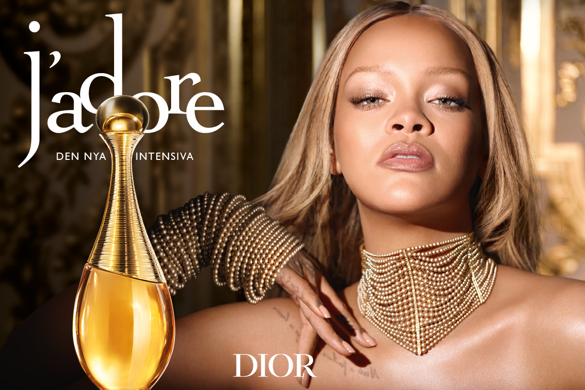 Dior J’adore parfymflaska tillsammans med en person som bär guldfärgat smycke, med texten “j’adore”, “DEN NYA INTENSIVA” och “DIOR”.