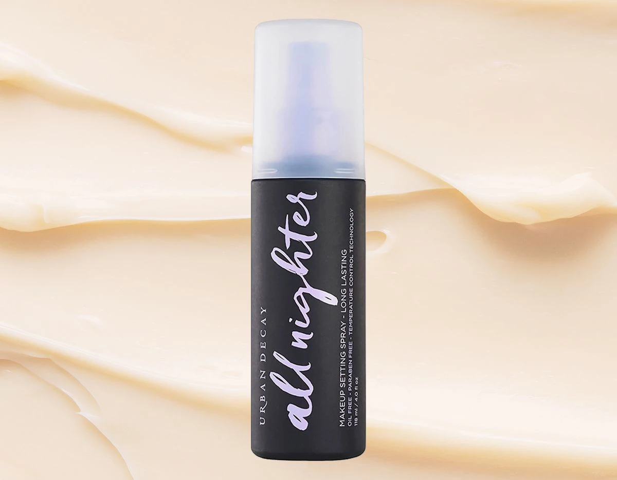 Urban Decayn All Nighter Setting Spray 118 ml beigeä, laskostettua taustaa vasten.