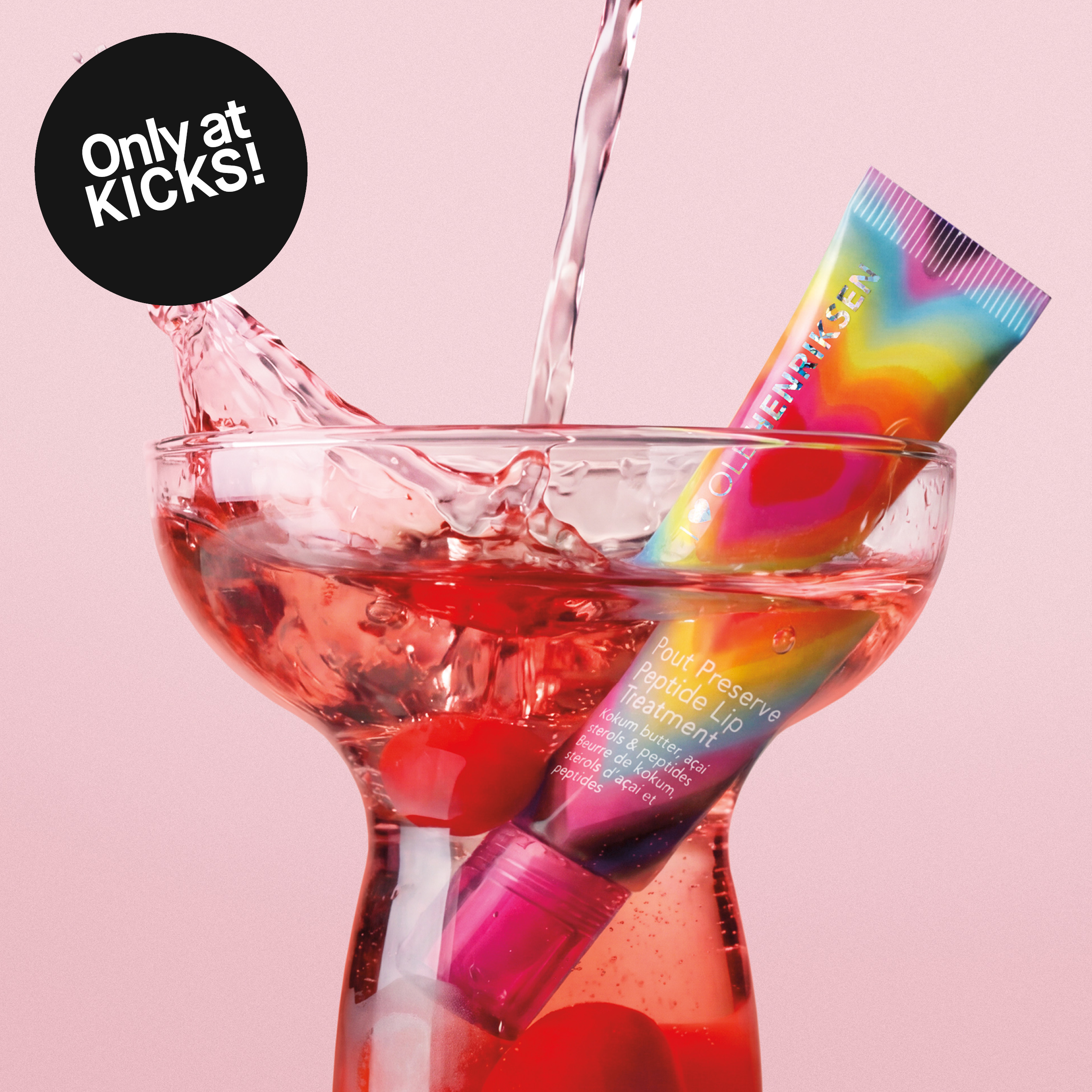 Ole Henriksen-läppbehandling i cocktailglas med vattensplash mot rosa bakgrund. Bilden innehåller texten ”Only at KICKS!”.