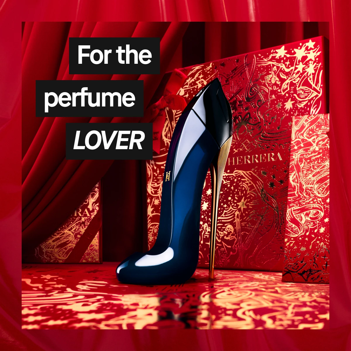 Carolina Herrera Good Girl Eau de Parfum i en mørkeblå flaske formet som høyhælte sko foran røde gardiner og gylne gaveesker – luksuriøs julekampanje for parfymeelskere.
