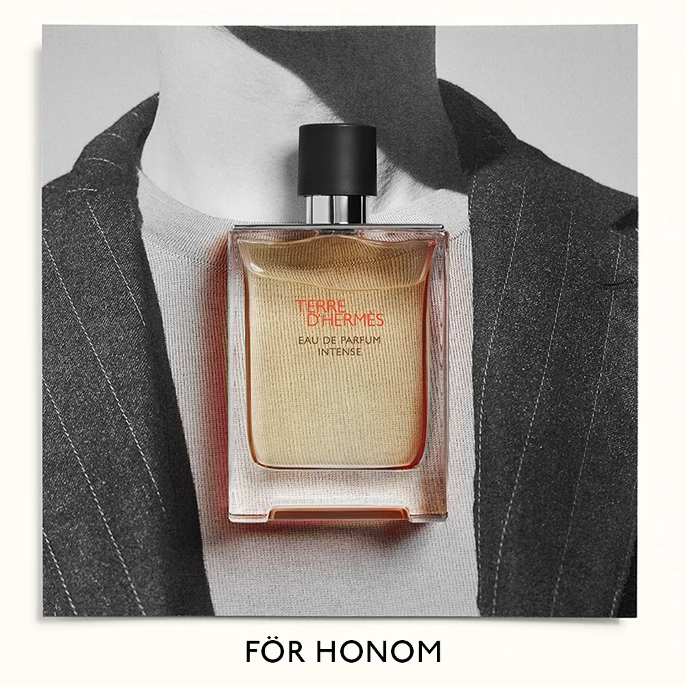 Parfymflaska från Hermès, Terre d'Hermès Eau de Parfum Intense, placerad framför en svartvit bild av en man i kostym. Texten "FÖR HONOM" syns längst ner.