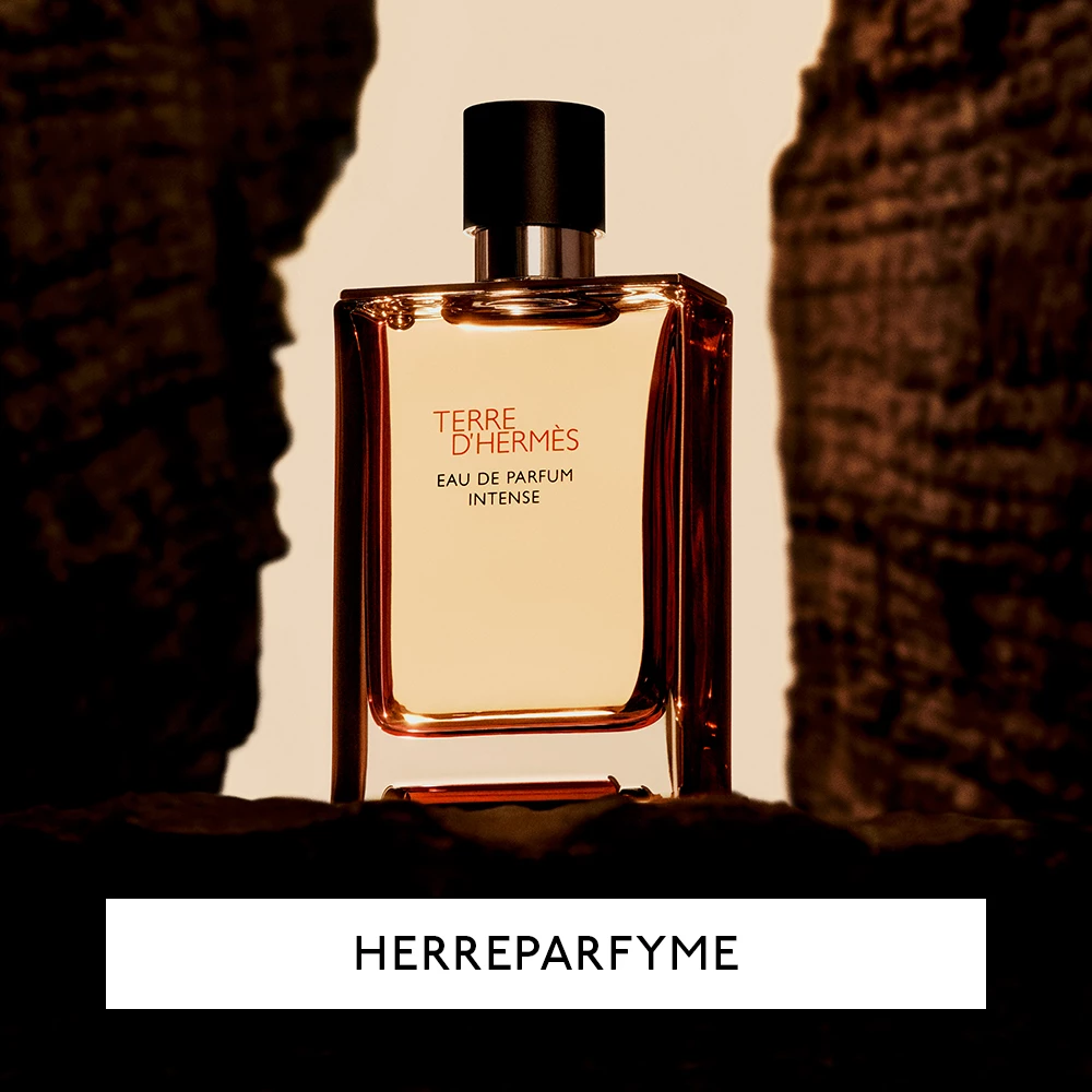 En flaske med Terre d'Hermès Eau de Parfum Intense, en herreparfyme. Flasken er plassert mellom to mørke steiner med en lys bakgrunn.