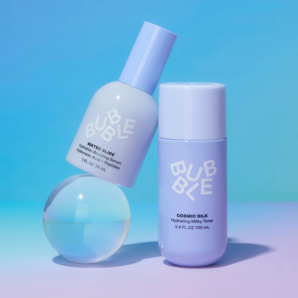 Bubble Water Slide-serum og Cosmic Silk-toner mot lyseblå bakgrunn.