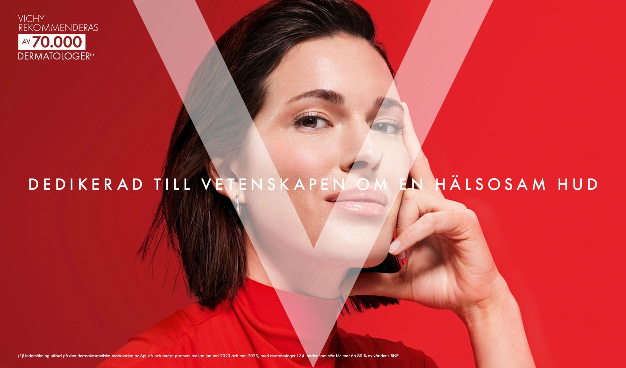 En person med kort, mörkt hår klädd i röd tröja håller handen mot ansiktet. Bakgrunden är röd med texten "Vichy rekommenderas av 70.000 dermatologer" och "Dedikerad till vetenskapen om hälsosam hud" synlig.