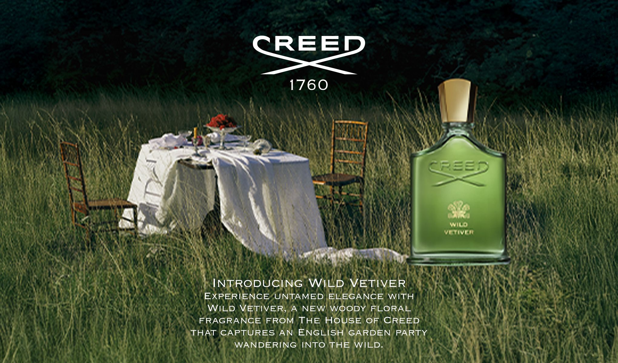 Creed Wild Vetiver -hajuvesipullo vihreässä lasipullossa kultaisella korkilla, jossa tekstit “CREED”, “WILD VETIVER” ja logo “CREED 1760”. Taustalla näkyy pöytä valkoisella liinalla ja tuoleja korkeassa ruohikossa sekä teksti “INTRODUCING WILD VETIVER Experience untamed elegance with Wild Vetiver, a new woody floral fragrance from The House of Creed that captures an English garden party wandering into the wild.”