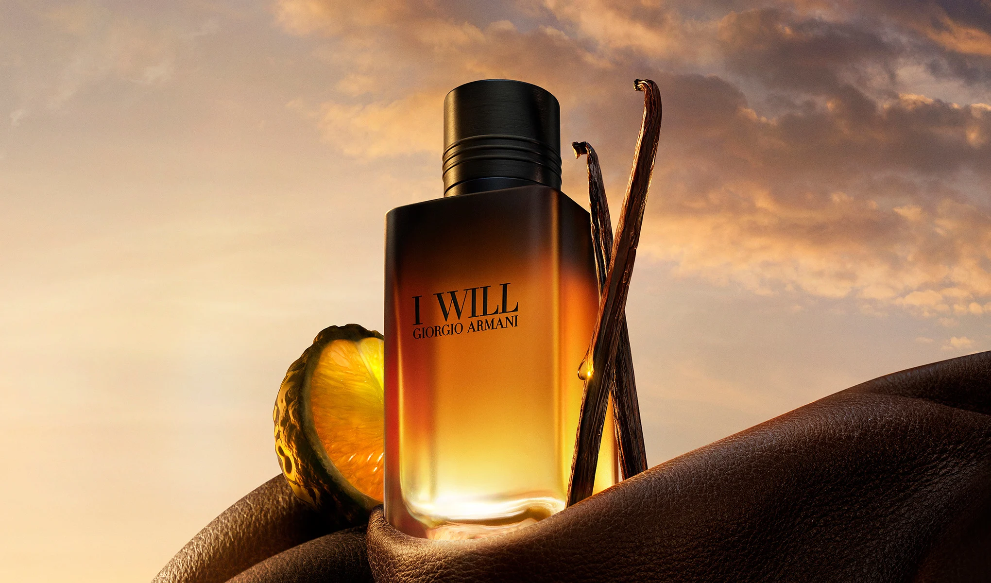 Giorgio Armani I Will-parfymeflaske med vaniljestenger og sitrusfrukt i varmt lys.