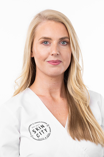 Kvinna med finurligt leende och långt blont hår med sidbena