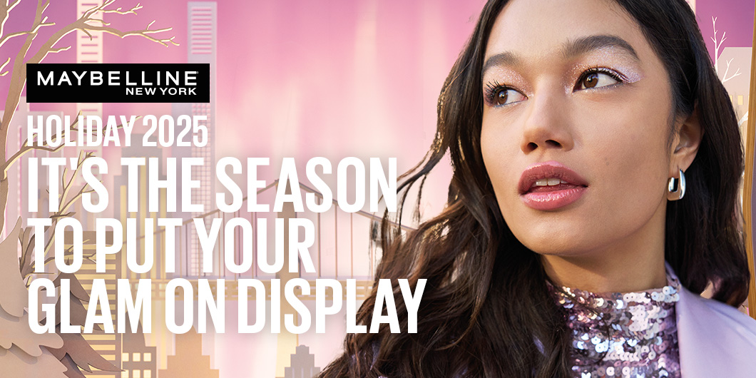 Maybelline New Yorkin mainos, jossa on vaaleanpunainen tausta ja teksti "Holiday 2025 - It's the season to put your glam on display". Kuvassa on henkilö, jolla on pitkät tummat hiukset ja kimaltava paita.