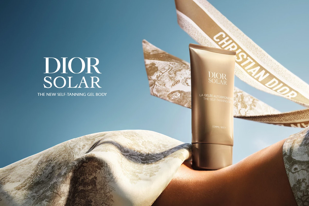 Dior Solar itseruskettava geeli on tyylikkäästi asetettu auringon suutelemaan ihoon, ja taustalla leijuu Christian Dior -nauhoja kirkkaan sinistä taivasta vasten.