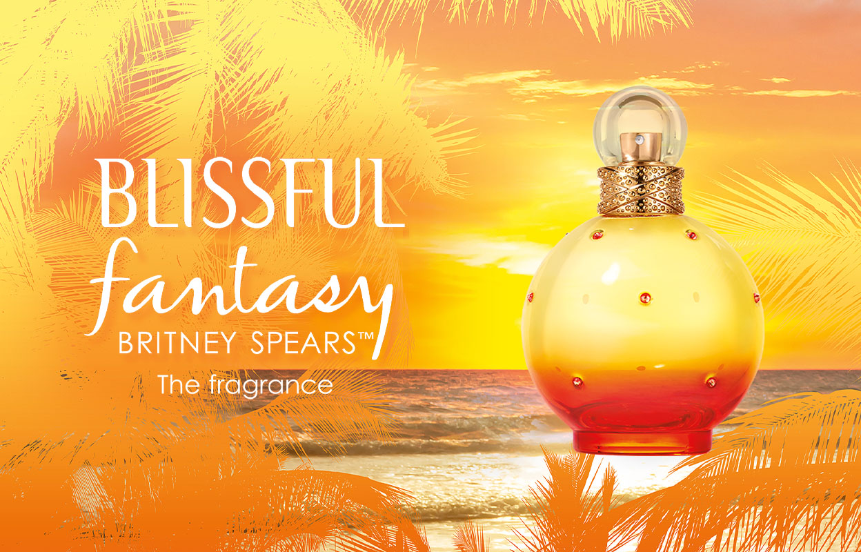 Britney Spearsin hajuvesipullo ”Blissful Fantasy”, taustalla rannan auringonlasku ja palmuja. Kuvassa on teksti ”Blissful fantasy Britney Spears™ The fragrance”. Pullo on keltainen ja oranssi, ja siinä on kultaisia ja punaisia yksityiskohtia.